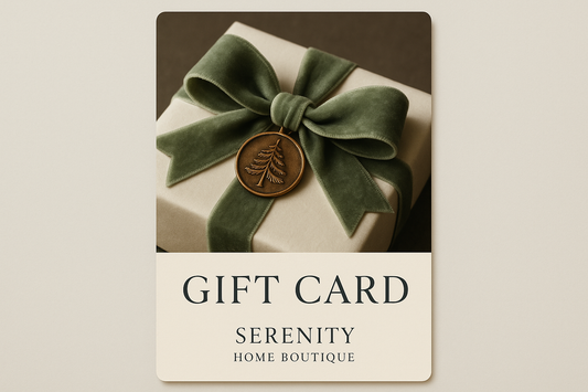 Create a gift card for Serenity Home Boutique that has a close up of a wrapped gift in ivory paper and a pale green velvet bow.  Attached to the bow is a bronze medallion with pine trees engraved on it.